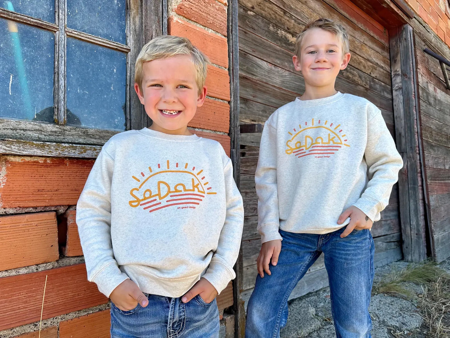SoDak Neon Sun Kids' Crewneck Sweatshirt by Oh Geez! Design