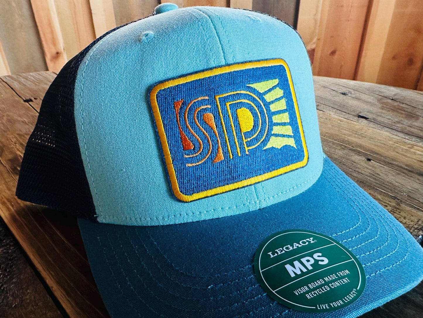 Teal  trucker hat with South Dakota logo patch