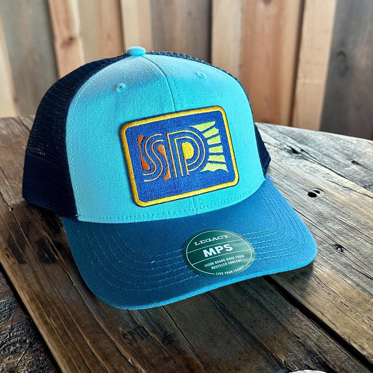 Blue three tone cap with South Dakota sun logo