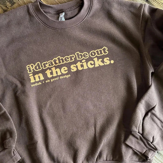 Brown sweatshirt with tan  text on a wooden surface